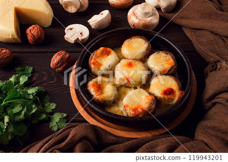 Traditional Georgian dish, appetizer, stuffed mushrooms, Sulguni cheese, baked in a Ketzi clay pan, on a wooden table, close-up, no people, Traditional Georgian dish, appetizer, stuffed mushrooms, Sulguni cheese, baked in a Ketzi clay pan, on a wooden table, close-up, no people, 119943201