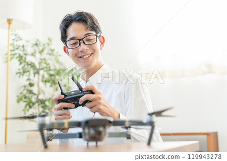 A young man operating a drone 119943278