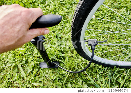 Inflating bicycle tire using floor pump with presta and schrader valve adaptor. 119944674