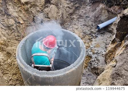 Diamond cutting wheel attached on angle grinder sawing concrete ring of septic tank. Diamond cutting wheel attached on angle grinder sawing concrete ring of septic tank. 119944675