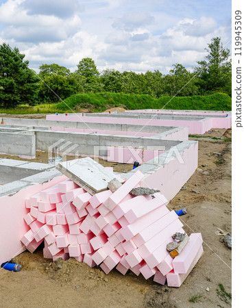 Thermal insulation with polystyrene plates around the perimeter of concrete foundations of a residential house Thermal insulation with polystyrene plates around the perimeter of concrete foundations of a residential house 119945309