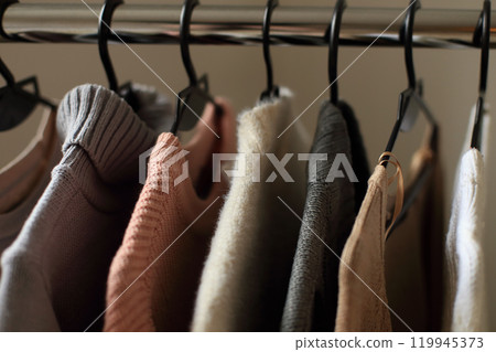 a collection of beautifully knitted items hanging in a well-organized manner on a hanger. The thoughtful arrangement highlights the vibrant colors and intricate patterns of each piece, reflecting a 119945373