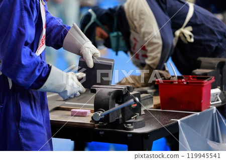 A craftsman filing a piece, removing burrs 119945541
