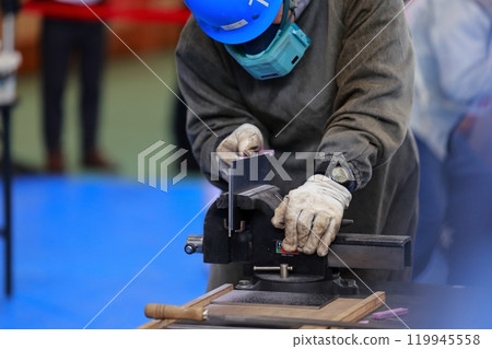 A craftsman filing a piece, removing burrs 119945558