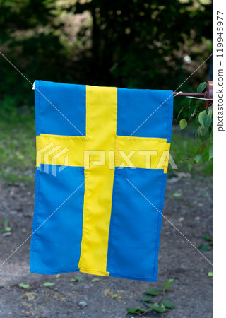 Traditional midsummer pole with small Swedish flag . 119945977