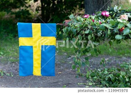 Traditional midsummer pole with small Swedish flag . 119945978