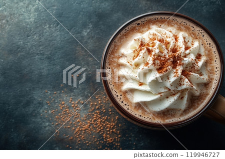 A steaming cup of rich hot chocolate is adorned with fluffy whipped cream and a dusting of cocoa. It rests on a dark countertop, inviting warmth on a chilly day. A steaming cup of rich hot chocolate is adorned with fluffy whipped cream and a dusting of cocoa. It rests on a dark countertop, inviting warmth on a chilly day. 119946727