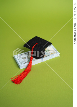 A stack of money and a graduation cap. Concept of a loan for education. Educational grants. Student loan concept. Educational grants. Unaffordable and expensive. High paying jobs. 119947518