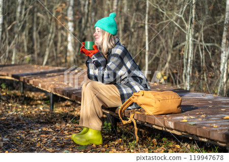 Time alone. Relaxed middle aged woman enjoy calm weekend in fall park meditative drinks thermos tea. Time alone. Relaxed middle aged woman enjoy calm weekend in fall park meditative drinks thermos tea. 119947678