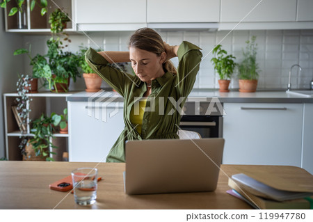 Overworked woman freelancer sitting at table with eyes closed, resting after long hard job on laptop Overworked woman freelancer sitting at table with eyes closed, resting after long hard job on laptop 119947780