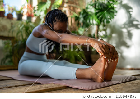 Young african american sportswoman stretching exercise warmup muscles before home fitness workout. Young african american sportswoman stretching exercise warmup muscles before home fitness workout. 119947853