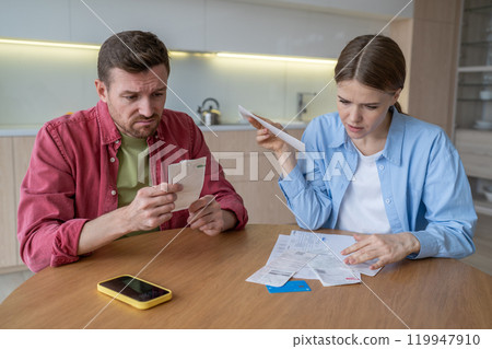 Distressed couple of man, woman sort bills, rent, utilities, dealing with debts and overdue payment 119947910