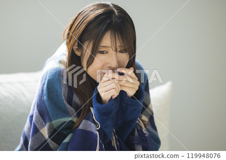 Woman feeling unwell in living room in winter Woman feeling unwell in living room in winter 119948076