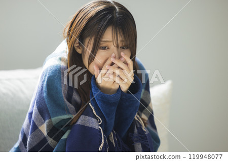 Woman feeling unwell in living room in winter Woman feeling unwell in living room in winter 119948077