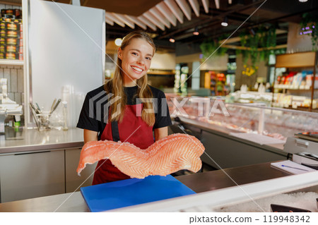 A Fresh Seafood Display showcased by a Smiling Salesperson, inviting customers to explore 119948342