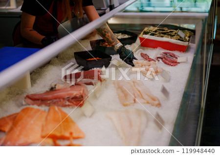 Fresh Seafood Display at a busy market featuring various fish and shellfish ready for selection Fresh Seafood Display at a busy market featuring various fish and shellfish ready for selection 119948440