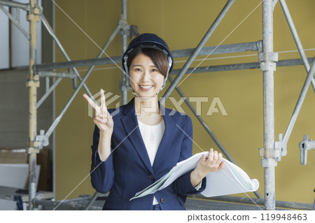 一位身穿西裝的女士在現場看圖紙 119948463