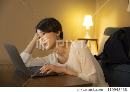 Business woman in the living room at night Business woman in the living room at night 119948488