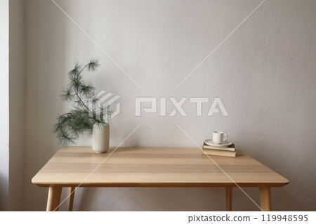 Elegant Christmas Scandi interior. Wooden desk table. Vase with pine tree branches, cup of coffee on old books. White wall background mockup. Minimal festive home decor, no people. Empty copy space. Elegant Christmas Scandi interior. Wooden desk table. Vase with pine tree branches, cup of coffee on old books. White wall background mockup. Minimal festive home decor, no people. Empty copy space. 119948595