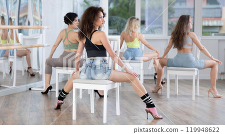 Brunette sitting on chair with back to camera during lap dance class 119948622