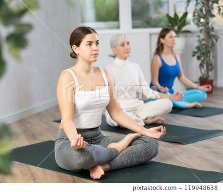 Young woman doing yoga in fitness studio 119948638