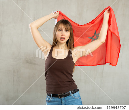 Young sad woman holding flag of Morocco Young sad woman holding flag of Morocco 119948707