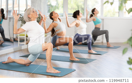 Elderly woman doing pilates in group in studio 119948711