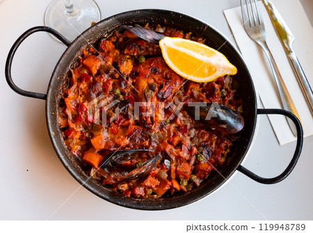 Spanish rice dish paella tinted with saffron. Prepared with olive oil and seafood 119948789