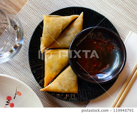Potato curry samosas served with sause at plate Potato curry samosas served with sause at plate 119948791
