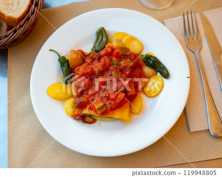 Spanish dish cod with sanfaina, sauteed vegetables and tomato sauce 119948805