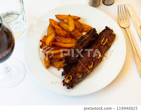 Spanish cuisine churrasco de ternera, spare ribs with potatoes on white ceramic plate 119948825