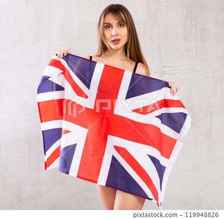 Young woman hiding behind flag of Great Britain Young woman hiding behind flag of Great Britain 119948826