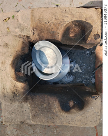 boiling milk inside muddy stove. Rural kitchen. Traditional stoves used by residents in rural India, pakistan, Bangladesh, nepal, afganistan, Sri Lanka and undeveloped countries. made of clay, fueled 119949078