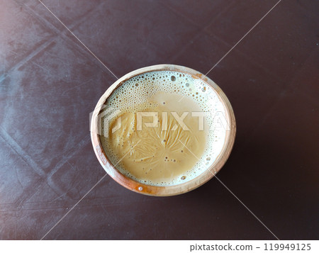 A kulhar or kulhad cup (traditional handle-less clay cup) from India filled with hot Indian tea. Indian desi cup for drinking tea 119949125