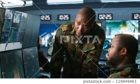 Team of soldiers looking at screens in command center housing operational missile defense system designed to intercept ballistic rockets. Tracking equipment operators using radar systems, camera A Team of soldiers looking at screens in command center housing operational missile defense system designed to intercept ballistic rockets. Tracking equipment operators using radar systems, camera A 119949461