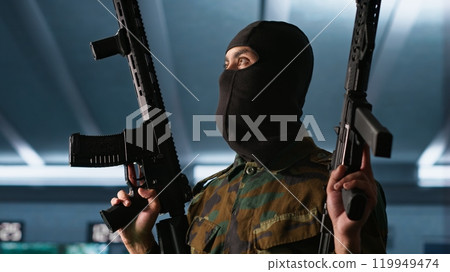 Terrorist holding rifles attacking enemy command post, looking around for threats. Insurgent inspecting room during enemy base assault hijacking in guerilla warfare armed conflict, camera A 119949474