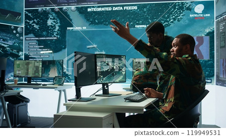 Government analysts work in an advanced command center with satellite radar systems, overseeing surveillance activities and interpreting real time data. Protecting national interests. Camera B. 119949531