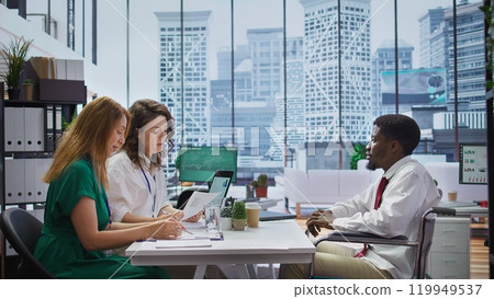 Candidate with chronic impairment attending a job interview in disability friendly office, discussing with the HR team about career development. Equal chances of employment. Camera B. 119949537