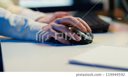 Extreme close up shot of video editor selecting key frames to use while doing video montage, working from home on computer. Woman using mouse to edit movie project footage in studio, camera A 119949592