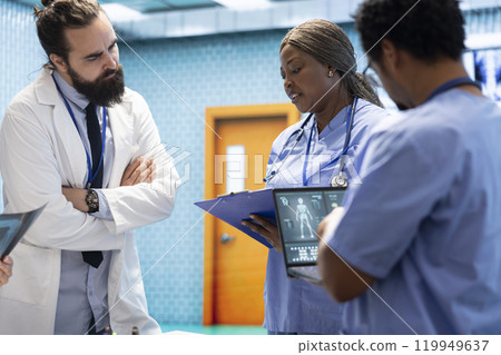 Healthcare team collaborates on human anatomy and diagnostic procedures. Group of specialists meeting in an office to discuss treatment plans after radiology test results. Disease prevention. Healthcare team collaborates on human anatomy and diagnostic procedures. Group of specialists meeting in an office to discuss treatment plans after radiology test results. Disease prevention. 119949637