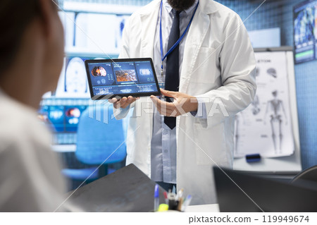 In a treatment center, healthcare professionals review mri scan test results and neurology x rays. Medics with neuroscience expertise ensuring development of treatment options, teamwork. In a treatment center, healthcare professionals review mri scan test results and neurology x rays. Medics with neuroscience expertise ensuring development of treatment options, teamwork. 119949674