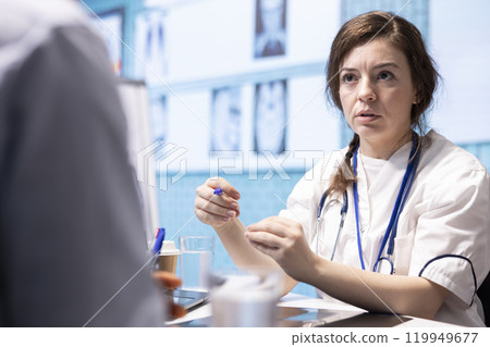 Physician meets with a patient to discuss medical results in a cabinet, using advanced diagnostic equipment to interpret x ray scans, demonstrating a professional healthcare approach. 119949677