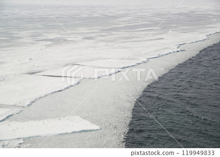 The ice-free Angara River flows out of the frozen Lake Baikal. Melted ice floes on blue water.  Located Baikal lake. 119949833