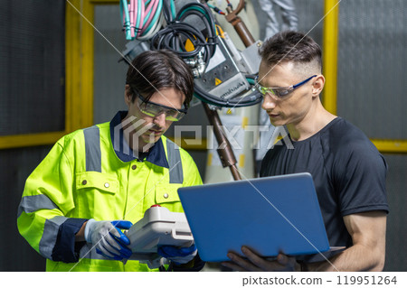 Technician engineer using laptop control automation robotics at industrial modern lab factory. male team technological researching and developing working at factory innovation automation robot. 119951264