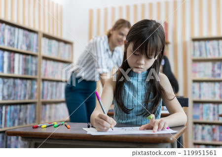 School children education in classroom. kid schoolgirl happy learning. Writing as instructed by teacher. concept of back to school. 119951561