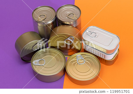 A Group of Stacked Tin Cans with Blank Edges on Split Orange and Violet Background A Group of Stacked Tin Cans with Blank Edges on Split Orange and Violet Background 119951701