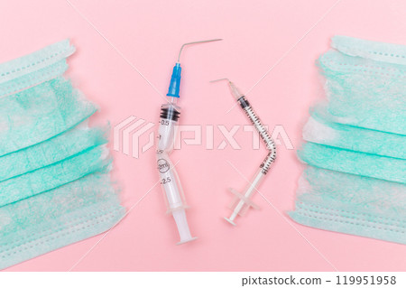 Broken Medical Syringe and Torn Medical Face Mask on the Pink Background 119951958