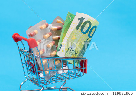 Pills and Capsules in Shopping Cart on Blue Background Pills and Capsules in Shopping Cart on Blue Background 119951969