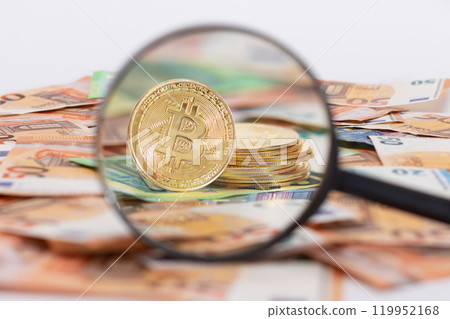 A Stack of Bitcoin Coins Visible Through a Magnifying Glass on the 50-Euro Banknotes A Stack of Bitcoin Coins Visible Through a Magnifying Glass on the 50-Euro Banknotes 119952168