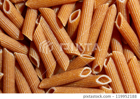 Uncooked Whole Grain Penne Rigate Pasta Background 119952188